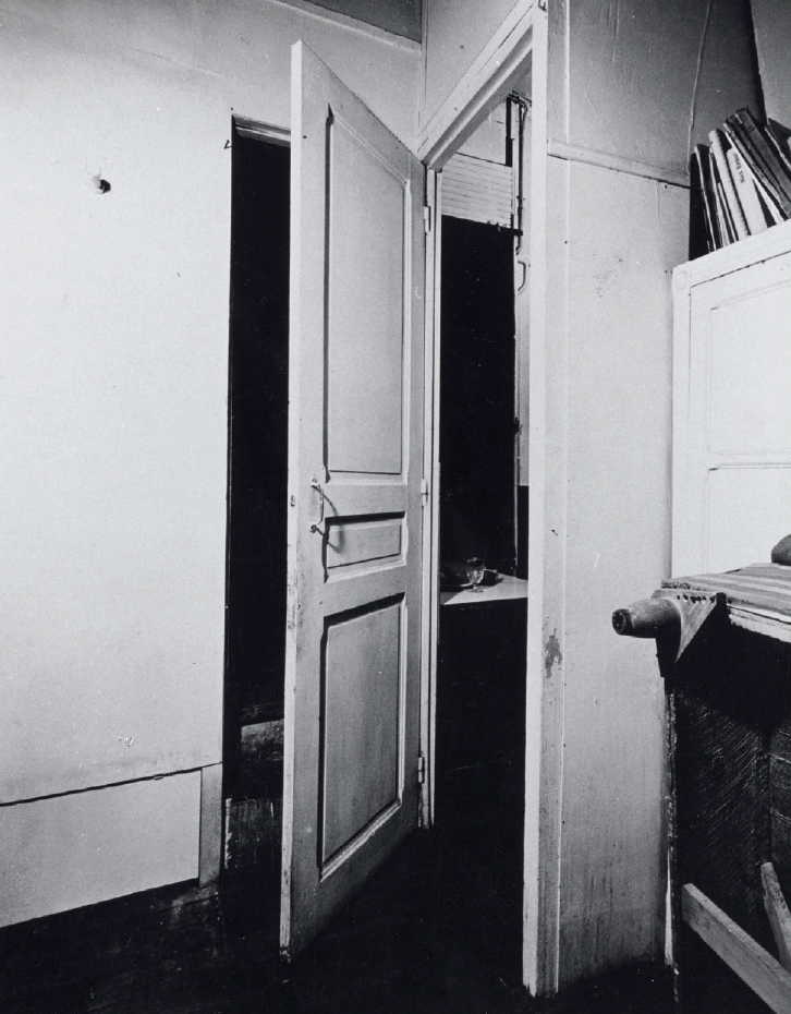 A door that faces two open rooms on a corner, hinged in the middle, making the door always simultaniously opening and closing a room.