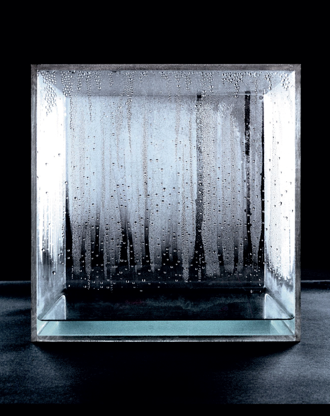 A glass cube with a layer of water that is condensating on the inside.